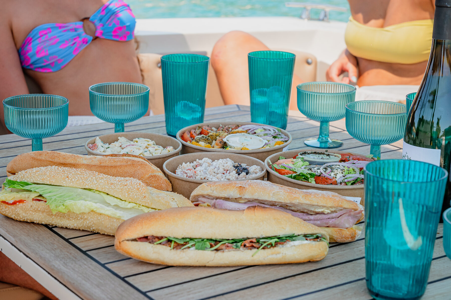 Paniers-repas Marinaloc sur la table du bateau : sandwichs, salades et boissons fraîches
